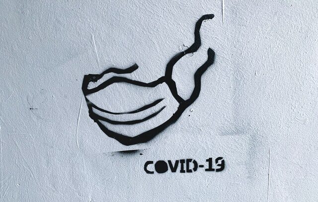 Covid-19 maski maalattu seinään